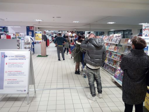 Clienti di un supermercato in fila per prelevare allo sportello Clienti di un supermercato in fila per prelevare allo sportello