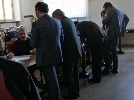 Imputati e avvocati durante una pausa del processo