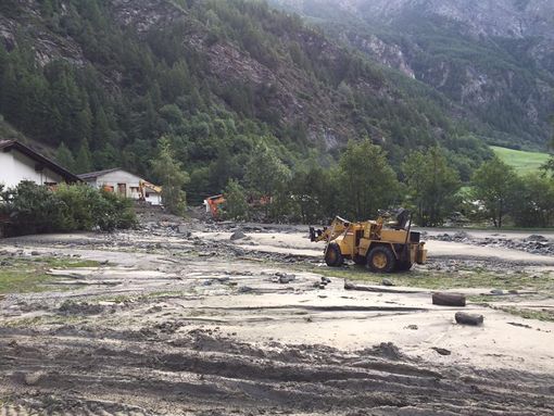 Nell'immagine di repertorio, uno scavatore impegnato nel ripristino di un'area inondata a Ollomont Nell'immagine di repertorio, uno scavatore impegnato nel ripristino di un'area inondata a Ollomont