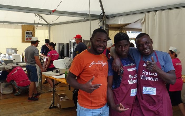 Tre giovani migranti ospiti in una struttura di Leone Rosso a Villeneuve impegnati alla Fiha di Barmé