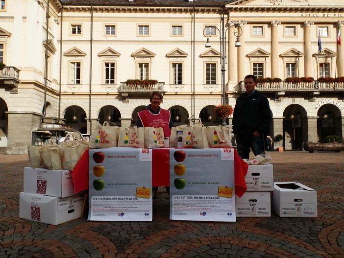 Due volontari dell'Aism offrono le 'mele per la vita' in piazza Chanoux ad Aosta