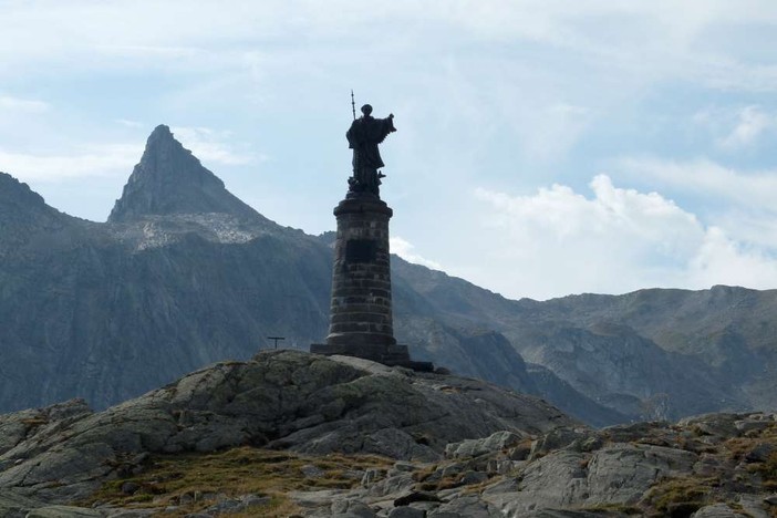 Statu al colle del Gran San Bernardo; nelkl'articolo una raffugurazione del santo e il colle del Piccolo san Bernardo
