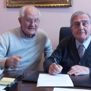 Luigino Valle (sn) e don Ferruccio Brunod alla firma del contratto. Don Brunod è morto il 1 maggio 2022